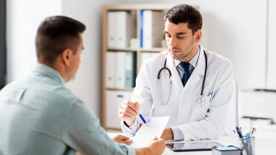 A doctor discussing treatment options with a patient in a hospital room.