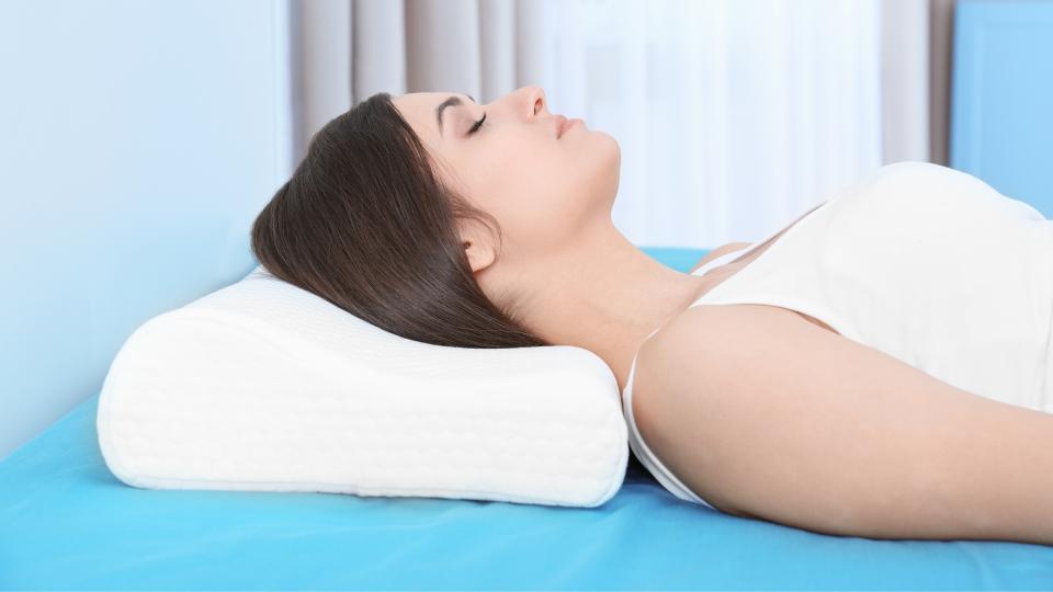 A woman lying on her back with a pillow, resting peacefully.