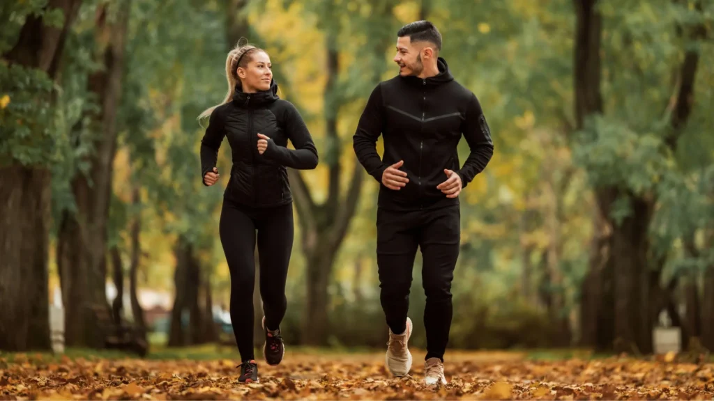 A couple jogging together in a beautiful park, enjoying the fresh air and staying fit.