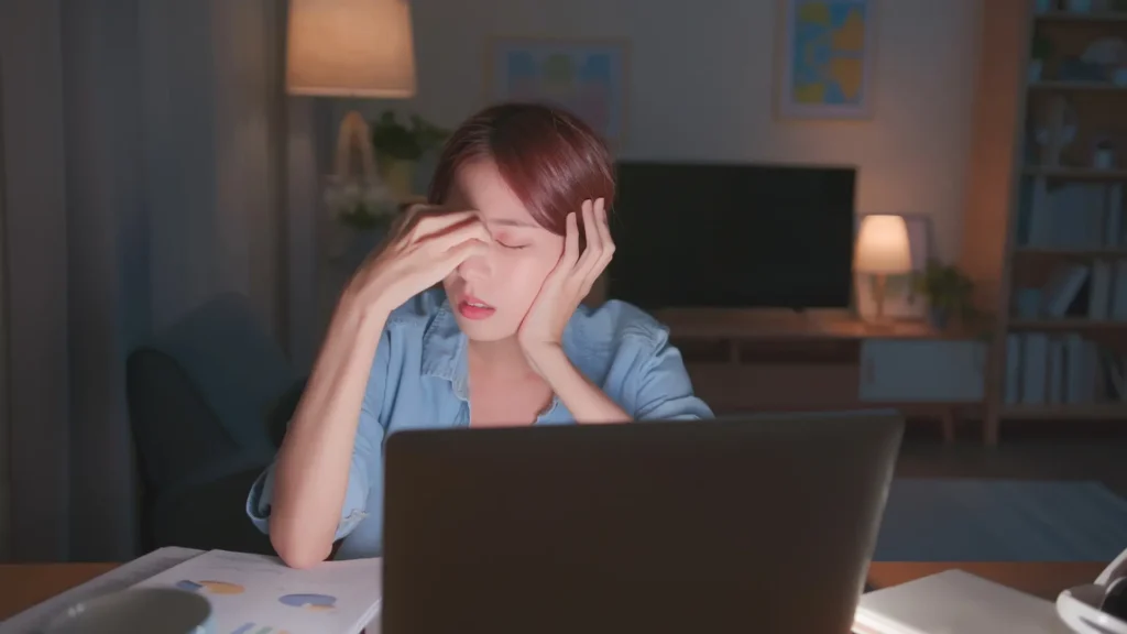 A woman sitting at a desk with her laptop, focused on her work.