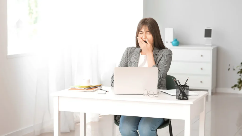 A woman focused on her laptop at a desk. How to Combat Sleep Deprivation Effectively