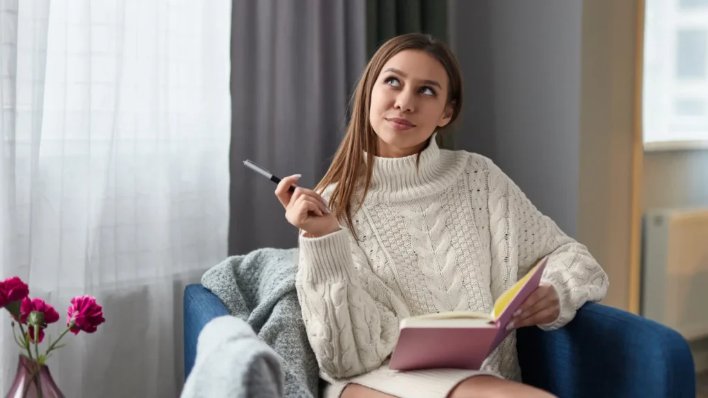 A woman on a couch writing in her diary