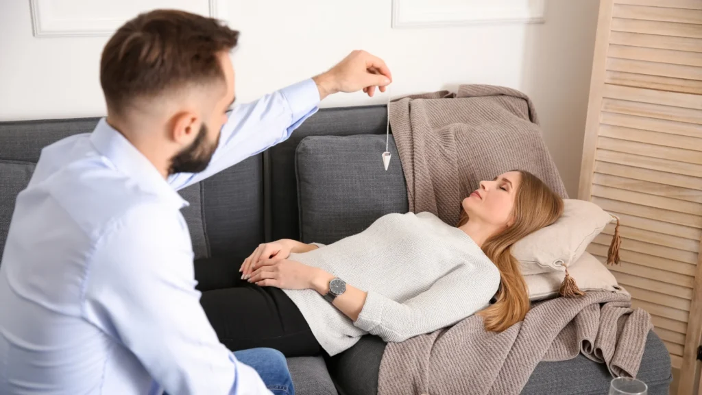 A man performing sleep hypnosis on a woman